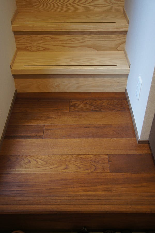 チークの床材と階段材はホワイトアッシュを。天然木材の木目の強い樹種同士、色のコントラストが見事です!