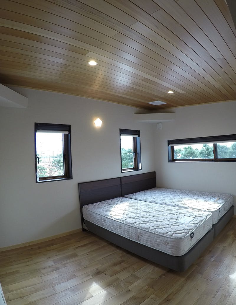 寝室天井にもおだやかな天然木材の木目のアガチスを